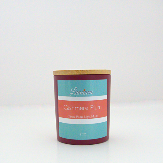 A 8oz frosted cashmere plum candle with a wooden lid sitting against a white background made by Eternel Luminen.