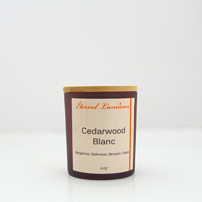 A 8oz frosted Cedarwood Blanc candle with a wooden lid sitting against a white background made by Eternel Luminen.