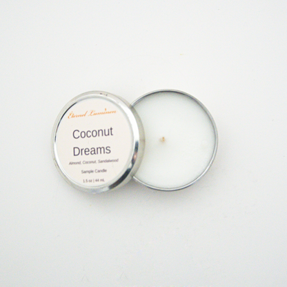 A 1.5oz Coconut Dreams sample candle in a tin jar with the lid off sitting against a white background made by Eternel Luminen.