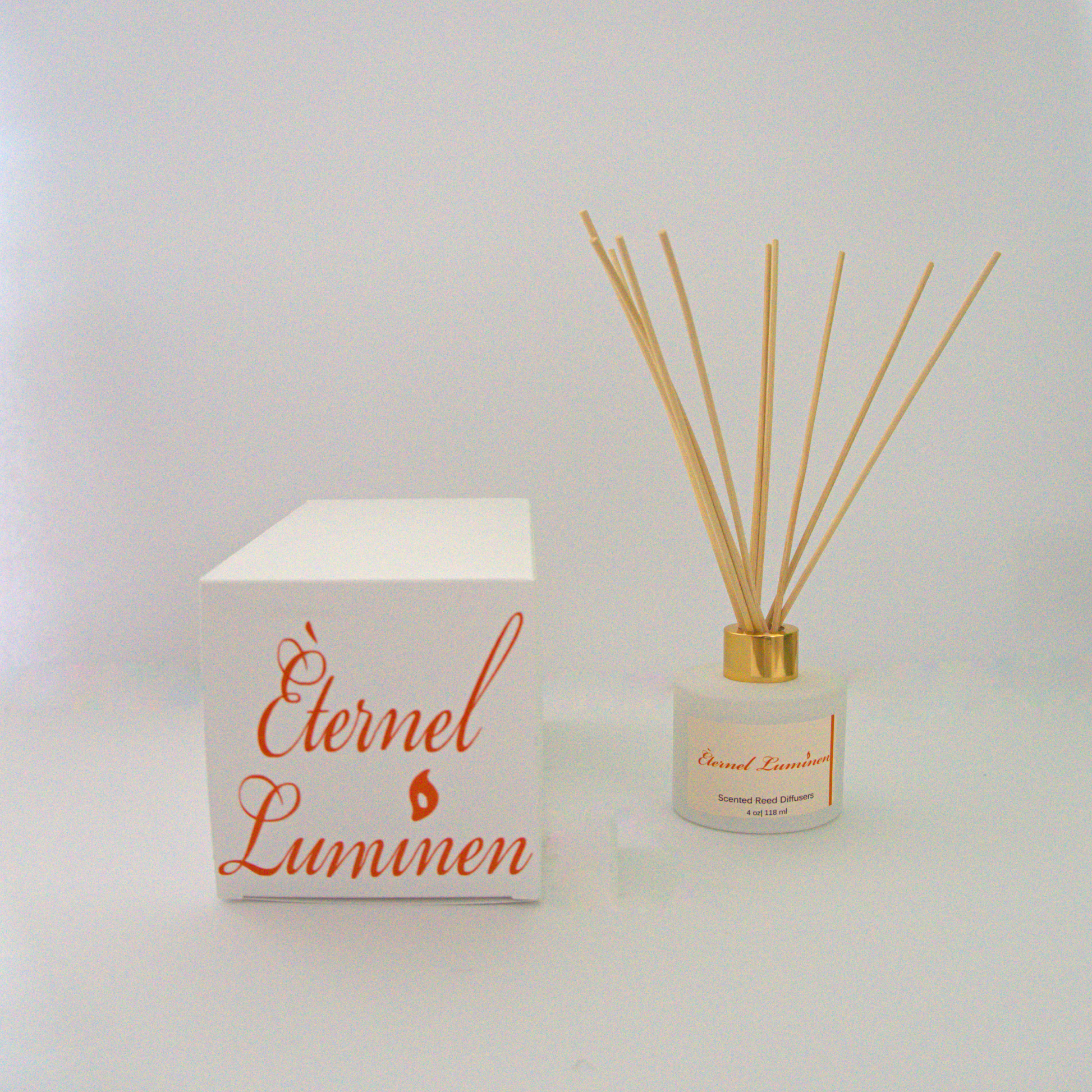 A 2.75 oz white jar with a gold band reed diffuser sitting against a white background and a box with the Eternel Luminen logo across the top.