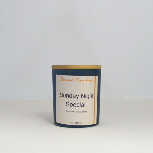 A 8oz Sunday Night Special frosted candle with a wooden lid sitting against a white background made by Eternel Luminen.